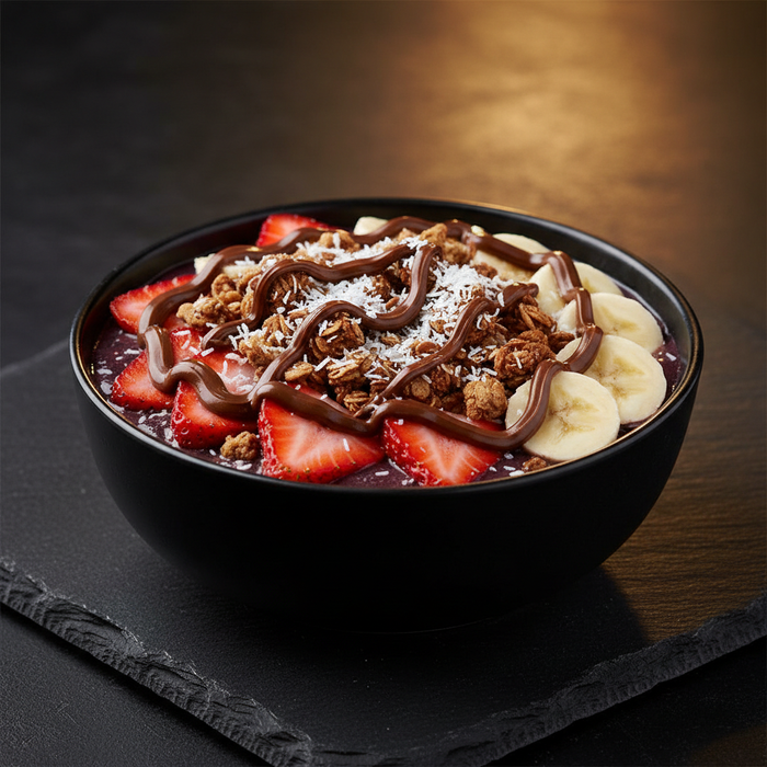Strawberry coconut Nutella acai bowl with blueberry flax granola, banana, and coconut flakes